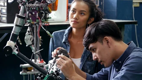 Engineering collaborating on develop of robot in laboratory together. Stock Footage 94062958