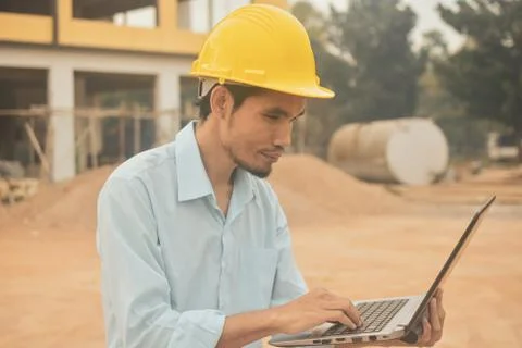 Engineering construction holding computer notebook inspection work at estate  Stock Photos