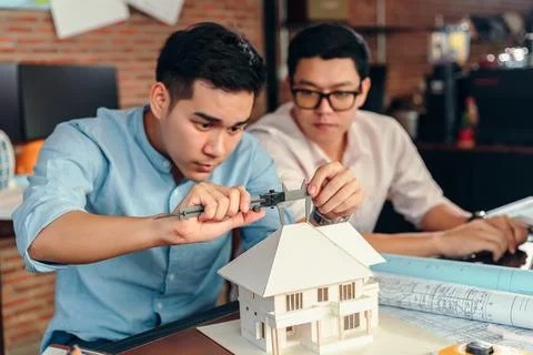 Engineering hands hold vernier caliper working and checking house model sca.. Stock Photos