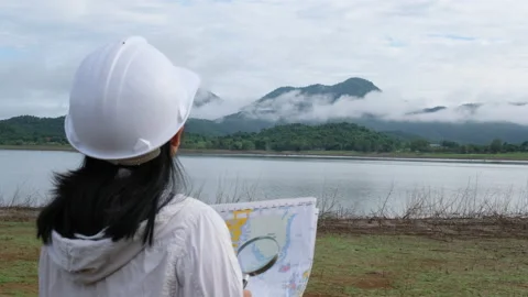 Engineering holding a riverbank map to develop a hydroelectric dam. Vídeo Stock 204394452