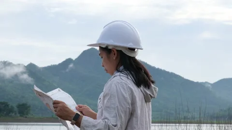 Engineering holding a riverbank map to develop a hydroelectric dam. Stock Footage 204410503