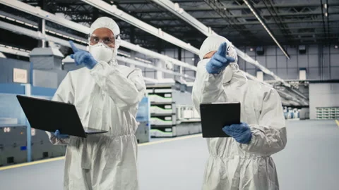 Engineering team brainstorming in microchip factory cleanroom, using devices Stock Footage 333393830