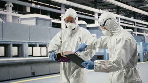 Engineering team brainstorming in microchip factory cleanroom, using devices Stock Footage 333395500