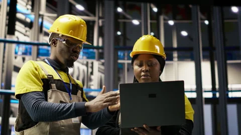 Engineering team doing brainstorming in smart factory, analyzing IoT sensor data Stock Footage 307366613
