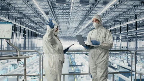 Engineering team evaluating advanced microchip silicon wafer prototype Stock Footage 333378443