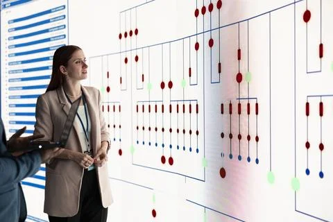 Engineering team inspecting PCB electrical grid schematics on screen Stock Photos