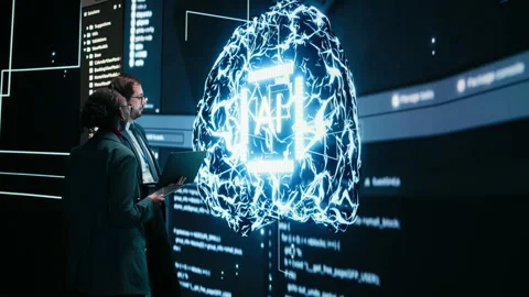 Engineering team looks at AI machine learning self writing code on screen Video stock 329591902