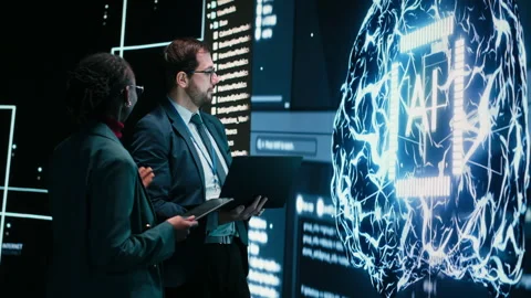 Engineering team looks at AI machine learning self writing code on screen Stock Footage 329944912