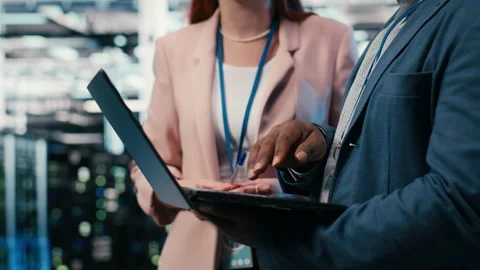 Engineering team solving tasks in server farm using laptop Stock Footage 330442309