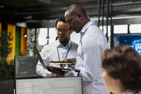 Engineering team testing AI machine learning algorithms at work using laptop Stockfoto's