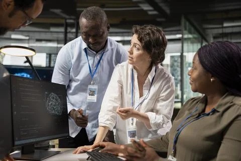 Engineering team working together, running AI algorithms on PC in startup Stock Photos