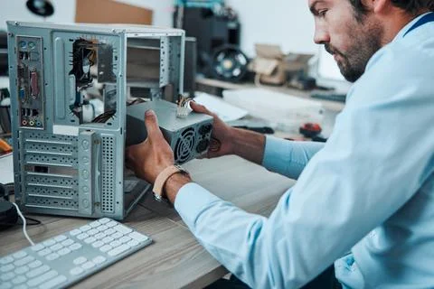 Engineering, technician and man fixing the hardware of a computer in workshop or Stock Photos