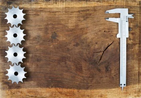 Engineering tools - gears and caliper on wooden table Stock Photos