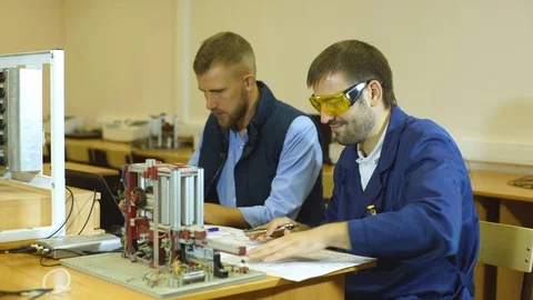 Engineering working in the lab, adjusting a 3D printer's components using a Stock Footage 70799060