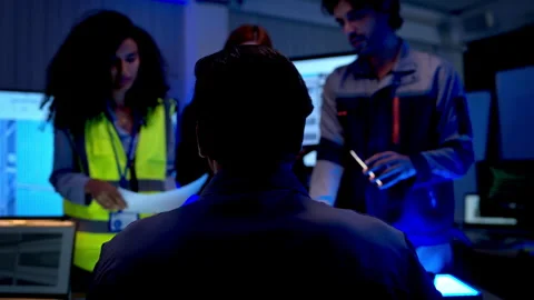 Engineers analyzing architectural building model and digital construction plans Stock Footage 340455181