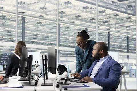 Engineers analyzing microchip architecture layouts on RD office computer Stock Photos