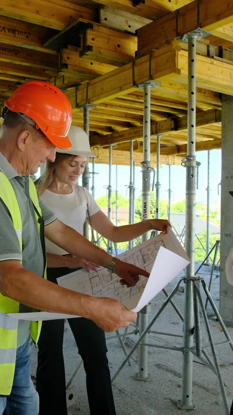 Engineers and builder inspect floor plan talking about project Stock Footage 317621898
