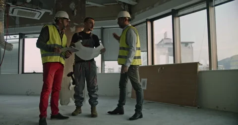 Engineers and Construction Worker Collaborate on Building Site, Reviewing Vídeos de archivo 313654656