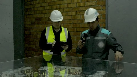 Engineers and construction workers examining a project blueprint on site Stock Footage 323169227