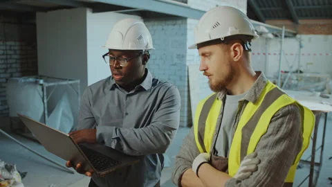 Engineers and Contractor Discussing Project on Laptop at Construction Site Stockbeeldmateriaal 273466812