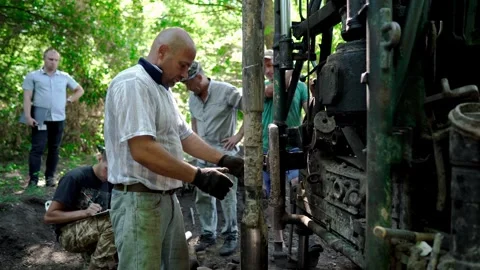 Engineers and drilling specialists operate the drilling equipment Stock Footage 338227228