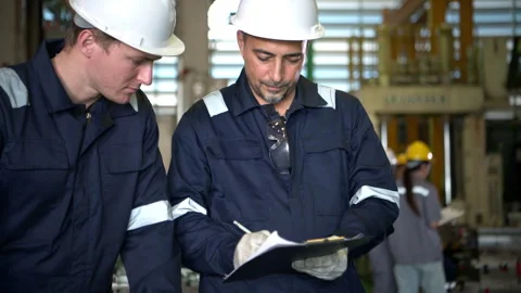 Engineers and factory technicians inspecting industrial machine parts Video stock 339079728
