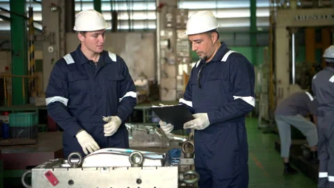 Engineers and factory technicians inspecting industrial machine parts Stock Footage 339080389