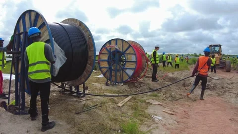 Engineers and technicians unreeling electrical DC cable laying it for inverter Stock Footage 327372273
