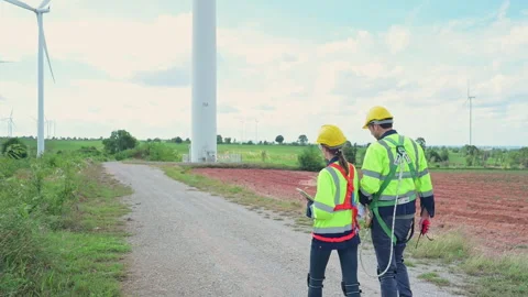 Engineers and wind turbines in a wind farm in the countryside Stock Footage 253985714