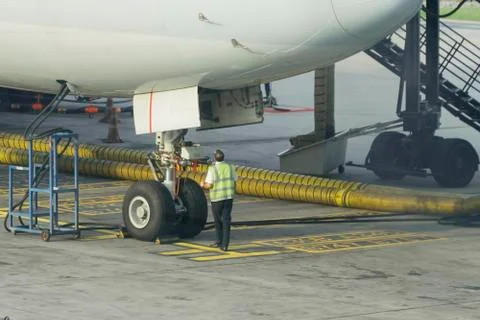 Engineers are checking the front wheels of the aircraft. Stock Photos