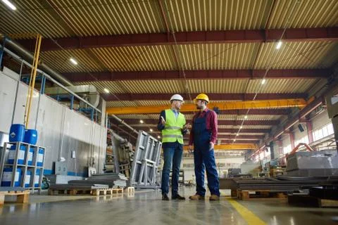 Engineers are discussing a new work plan at the plant. Stock Photos