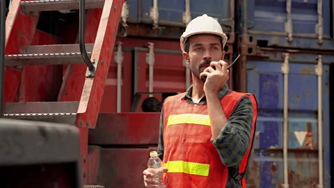 Engineers are drinking water from bottles while using radio to communicate Stock Footage 131262211