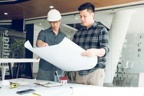 Engineers are helping to design work on blueprints and collaborate on struc.. Stock Photos