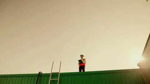 Engineers are standing to check the specs of work on factory roofs Stock Footage 164451079