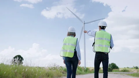 Engineers are standing together discussing wind power projects and work Stock Footage 166313379