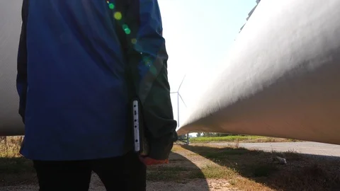 Engineers are working outdoors to check the wind turbine system with a tablet  Stock Footage 121204166
