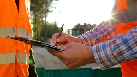 Engineers builders at the construction site reviewing the drawings Vídeo Stock 75780686