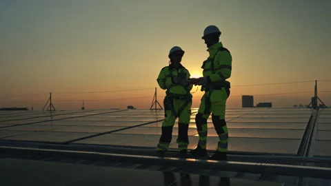 Engineers celebrating successful solar panel installation on a rooftop at sunset 스톡 동영상 339649766