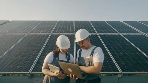 Engineers check the panel performance data using a laptop and discuss it. Stock Footage 264070486
