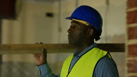 Engineers checking ceiling and carrying wooden beam at construction site Stock Footage 108150136