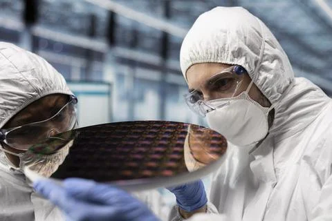 Engineers checking silicon wafer hardware defects in industry 4.0 plant Stock Photos