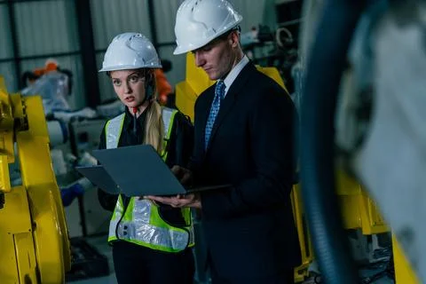 Engineers collaborate on project in industrial setting with advanced machin.. Stock Photos