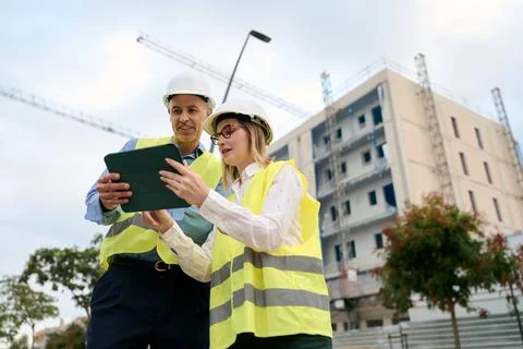 Engineers collaborating on construction site using tablet Stock Photos