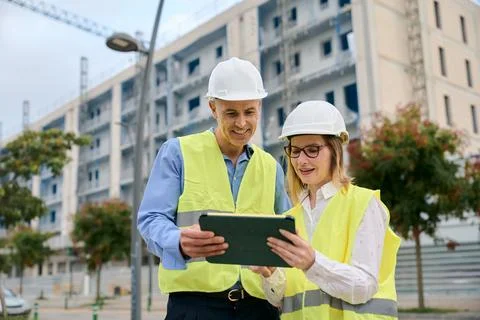 Engineers collaborating on construction site using digital tablet Stock Photos