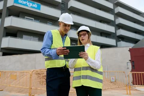 Engineers collaborating on construction site using tablet Stock Photos
