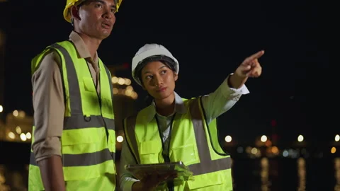 Engineers collaborating on tablet at night site Stock Footage 293423429
