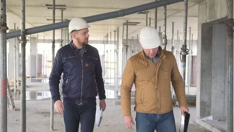 Engineers coming indoor of construction and start talkig about builiding work. 库存影片 72359018