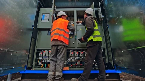 Engineers connect electrical system outdoors. Video stock 130018680