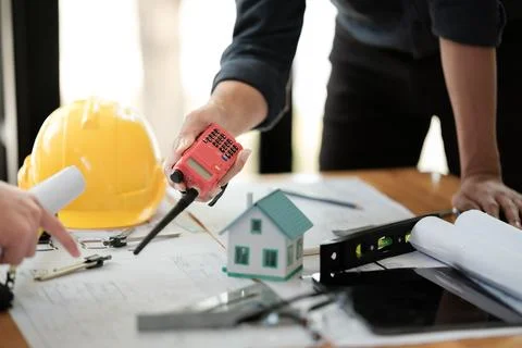Engineers consulting team close up to design building blueprints paper for Stock Photos