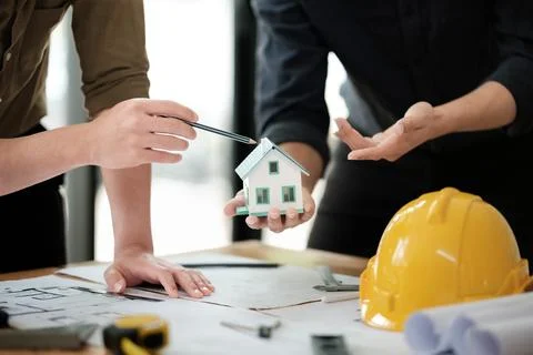 Engineers consulting team close up to design building blueprints paper for Stock Photos